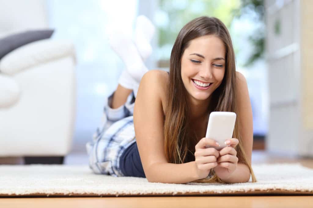 A woman smiling at her phone
